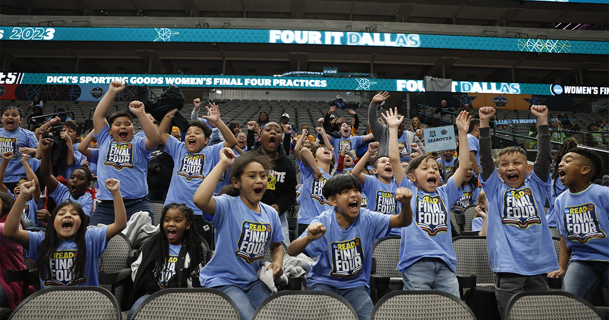 Children cheering in stands wearing Read to the Final Four tshirts. Photo credit to © NCAA.